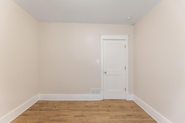 empty room featuring baseboards, light wood-style flooring, and visible vents