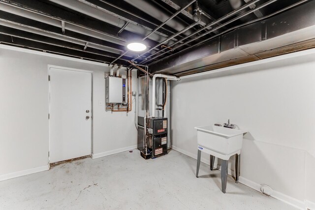 finished below grade area with a sink, electric panel, and baseboards