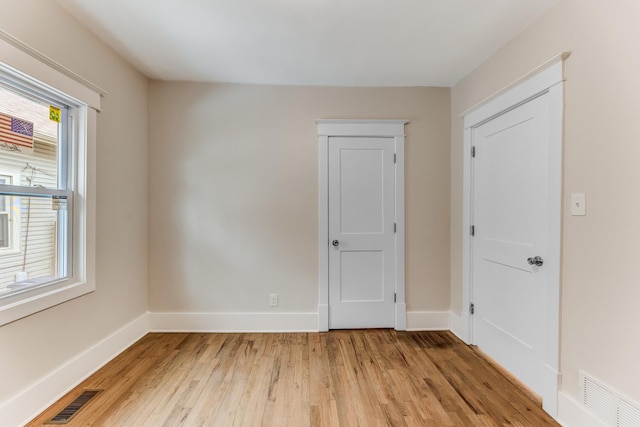 empty room featuring baseboards, visible vents, and light wood-type flooring
