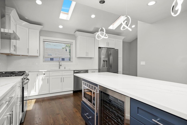 kitchen with white cabinetry, appliances with stainless steel finishes, a sink, and wine cooler
