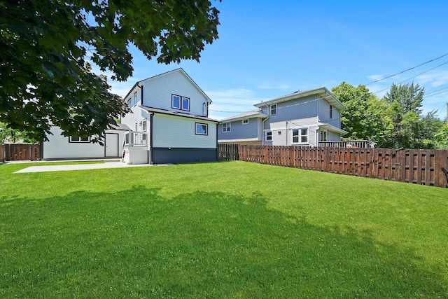back of property featuring a lawn and fence
