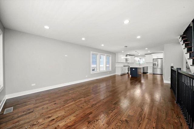 unfurnished living room featuring stairs, visible vents, recessed lighting, dark wood-style floors, and baseboards