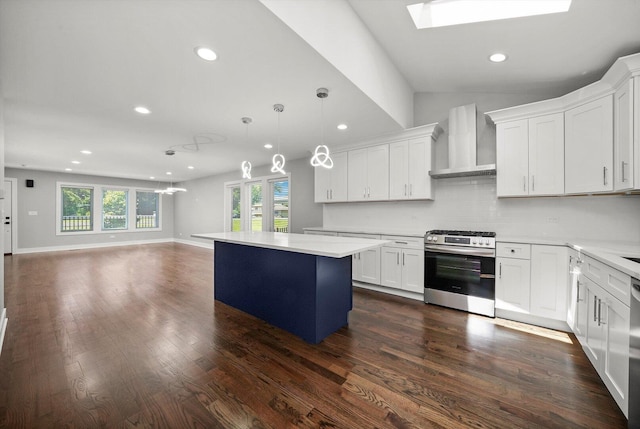 kitchen with stainless steel gas range, wall chimney exhaust hood, a healthy amount of sunlight, a kitchen island, and recessed lighting