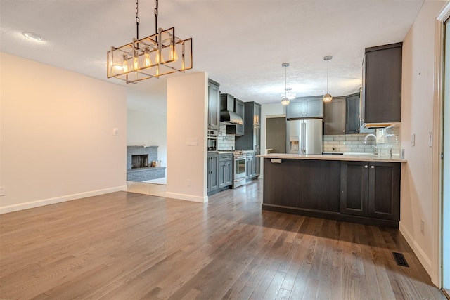 1306 Ewing St, Bloomington, IL 61701 - kitchen with open floor plan, dark wood-style floors, wall chimney exhaust hood, backsplash, and stainless steel appliances