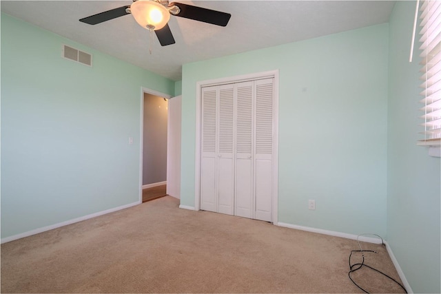 1306 Ewing St, Bloomington, IL 61701 - unfurnished bedroom with visible vents, a closet, baseboards, light colored carpet, and a ceiling fan
