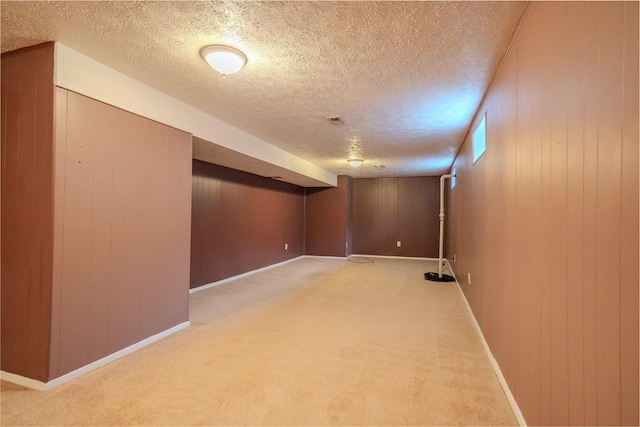 1306 Ewing St, Bloomington, IL 61701 - finished below grade area with wooden walls, baseboards, light carpet, and a textured ceiling