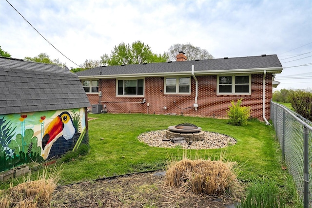 1306 Ewing St, Bloomington, IL 61701 - back of property with a chimney, brick siding, a fenced backyard, a yard, and a fire pit