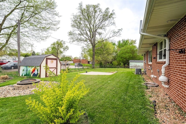 1306 Ewing St, Bloomington, IL 61701 - view of yard featuring fence, a storage shed, an outdoor fire pit, central air condition unit, and an outbuilding