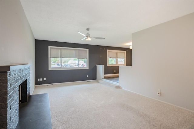 1306 Ewing St, Bloomington, IL 61701 - unfurnished living room featuring baseboards, a fireplace with raised hearth, carpet, and ceiling fan