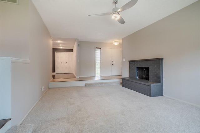 1306 Ewing St, Bloomington, IL 61701 - unfurnished living room with carpet flooring, a brick fireplace, a ceiling fan, baseboards, and visible vents