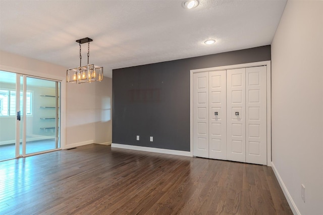 1306 Ewing St, Bloomington, IL 61701 - unfurnished dining area featuring a chandelier, baseboards, dark wood finished floors, and visible vents