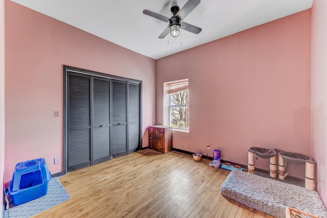 bedroom with a closet, hardwood / wood-style flooring, and baseboards