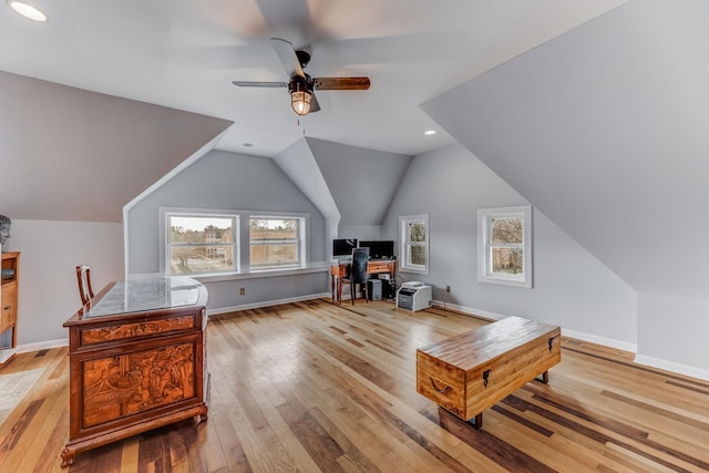 office space with ceiling fan, vaulted ceiling, hardwood / wood-style flooring, and baseboards