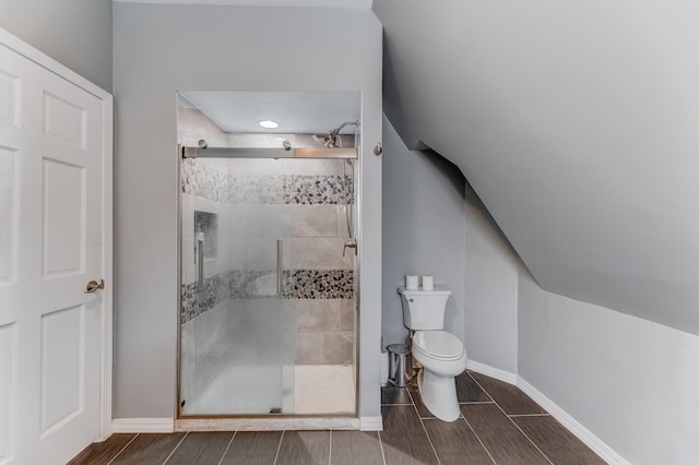 full bath with toilet, a shower stall, wood finish floors, and baseboards