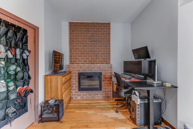 office featuring wood finished floors and a fireplace