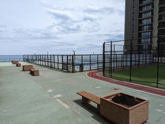 view of property's community with fence and a water view
