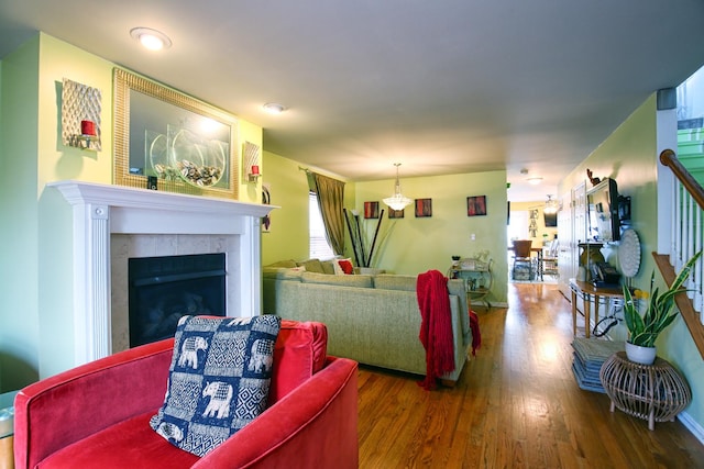 living area featuring stairs, wood finished floors, and a fireplace