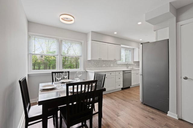 dining area with light wood-style floors and baseboards