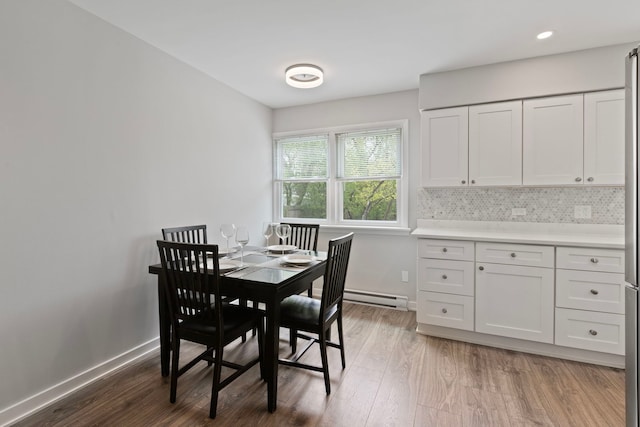 dining area featuring baseboards, wood finished floors, and baseboard heating
