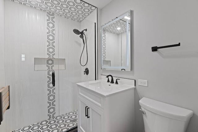 full bath featuring vanity, toilet, and tiled shower