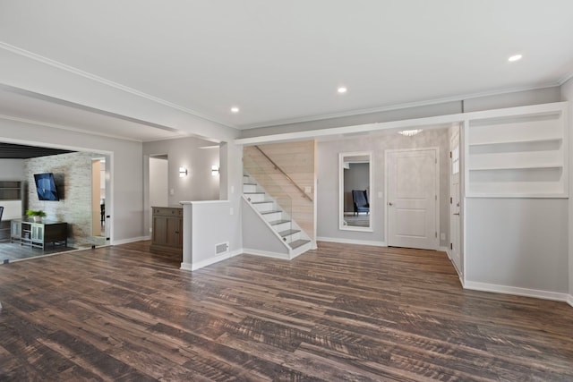 basement featuring visible vents, dark wood-style flooring, baseboards, ornamental molding, and stairs