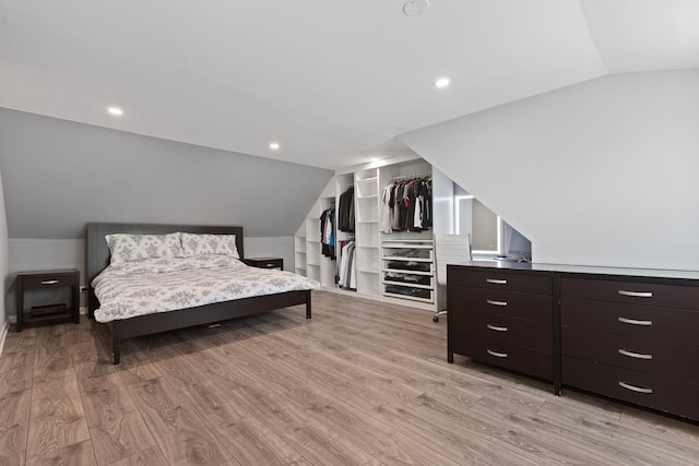 bedroom featuring vaulted ceiling, light wood finished floors, and recessed lighting