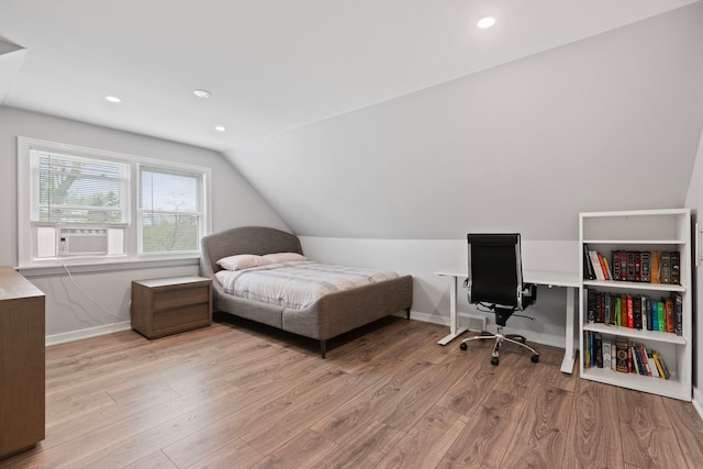 bedroom featuring vaulted ceiling, baseboards, cooling unit, and wood finished floors