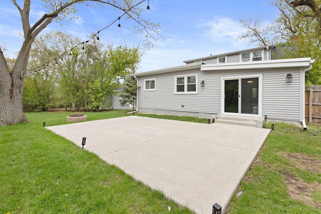 rear view of house featuring fence, a patio area, a yard, entry steps, and an outdoor fire pit