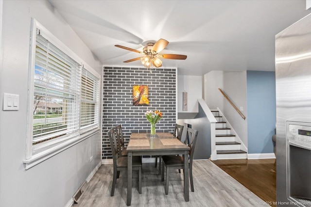 dining space with stairway, baseboards, ceiling fan, and wood finished floors