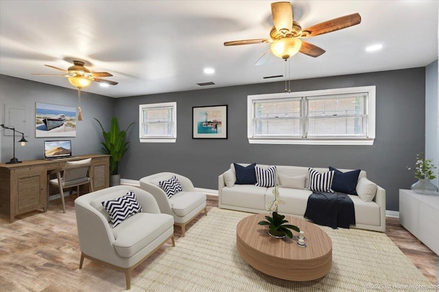 living area with light wood-style floors, a ceiling fan, visible vents, and recessed lighting