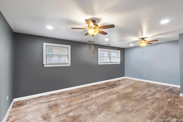 empty room with a ceiling fan, baseboards, recessed lighting, and wood finished floors