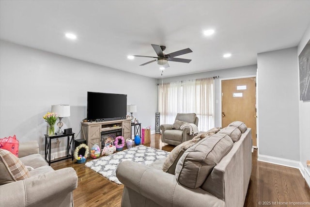 living area with baseboards, ceiling fan, recessed lighting, and dark wood-type flooring