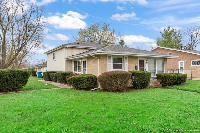 view of home's exterior featuring a lawn, brick siding, fence, and roof with shingles