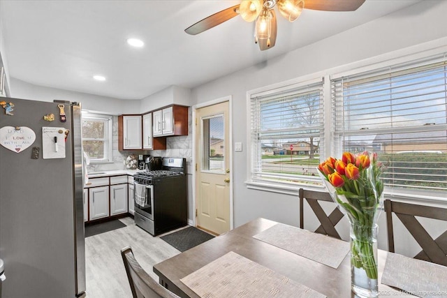 kitchen featuring ceiling fan, backsplash, light wood finished floors, stainless steel appliances, and recessed lighting