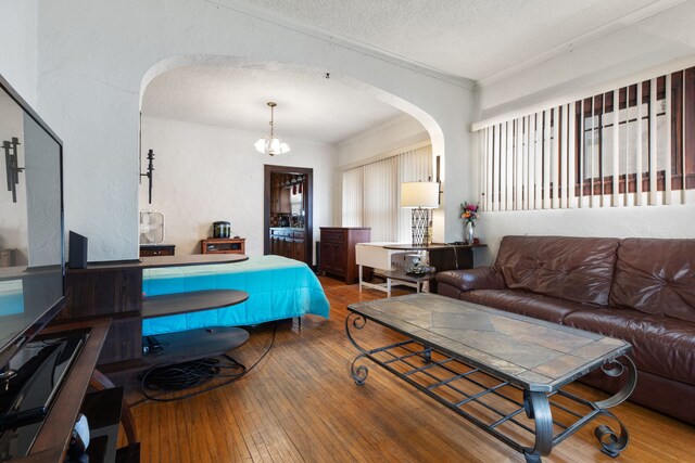 420 N Hebbard St, Joliet, IL 60432 - living area with arched walkways, wood-type flooring, crown molding, a textured ceiling, and a chandelier