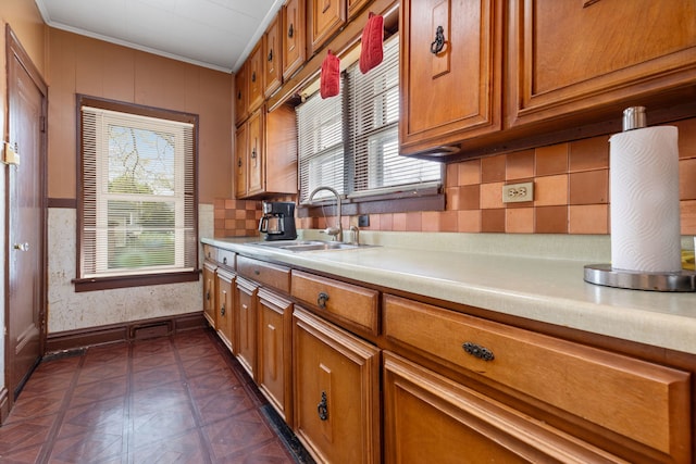 420 N Hebbard St, Joliet, IL 60432 - kitchen featuring brown cabinets, a sink, light countertops, ornamental molding, and decorative backsplash