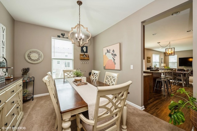 dining space featuring baseboards, a chandelier, and a wealth of natural light