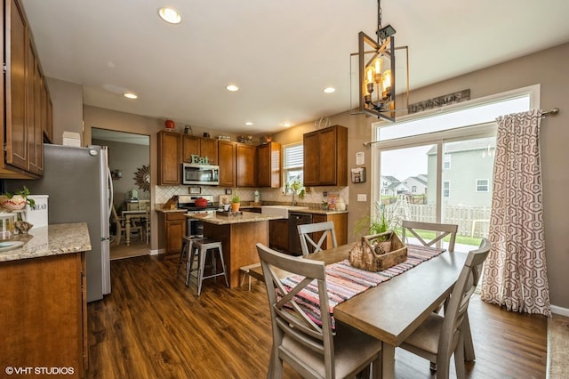 dining room with recessed lighting, baseboards, dark wood finished floors, and a chandelier