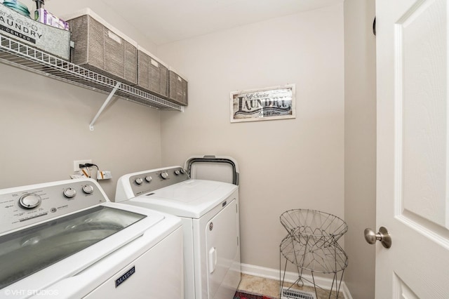laundry room featuring laundry area, baseboards, light tile patterned flooring, and separate washer and dryer