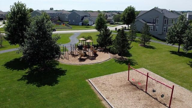 view of property's community with a lawn, a residential view, and playground community
