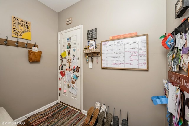 entryway with baseboards and carpet floors