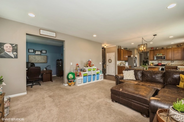 living room with recessed lighting, baseboards, light colored carpet, and an inviting chandelier