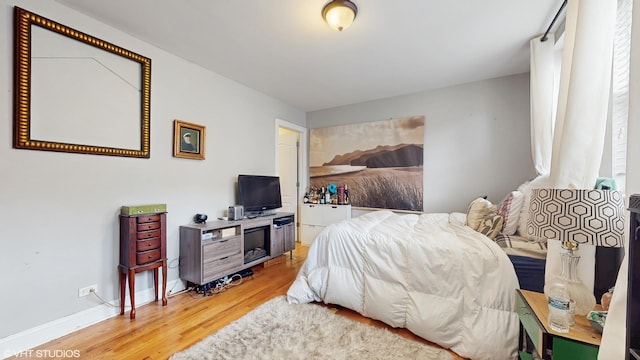 bedroom featuring baseboards and light wood finished floors