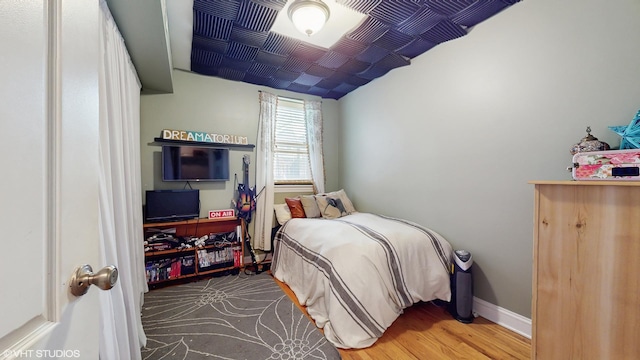 bedroom featuring baseboards and wood finished floors