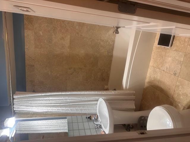 full bath with tile walls, walk in shower, and a bath