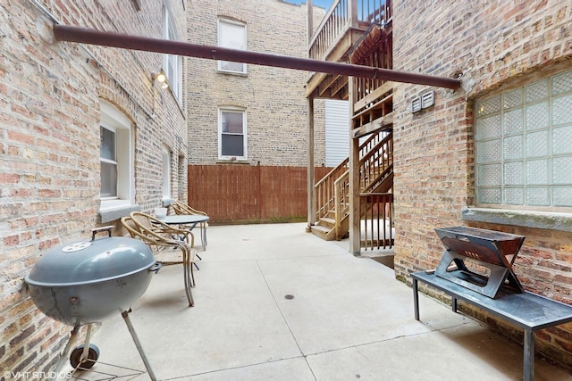 view of patio / terrace with grilling area, fence, and stairs