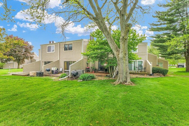 rear view of property featuring a patio, central AC unit, and a yard