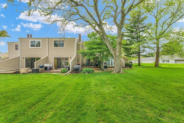 rear view of property with a yard