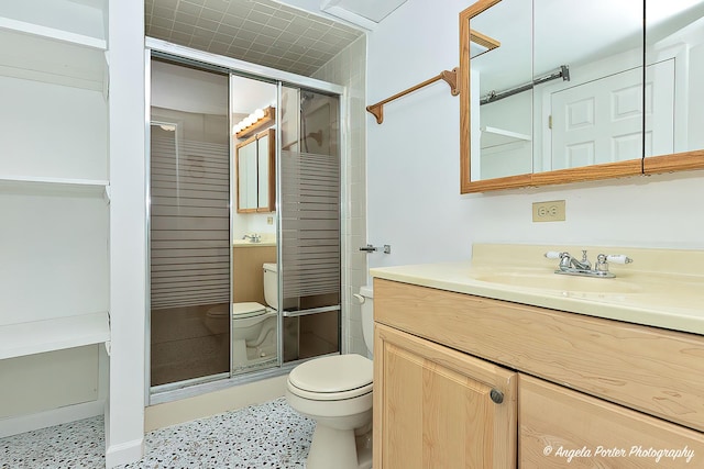bathroom featuring vanity, toilet, speckled floor, and a stall shower