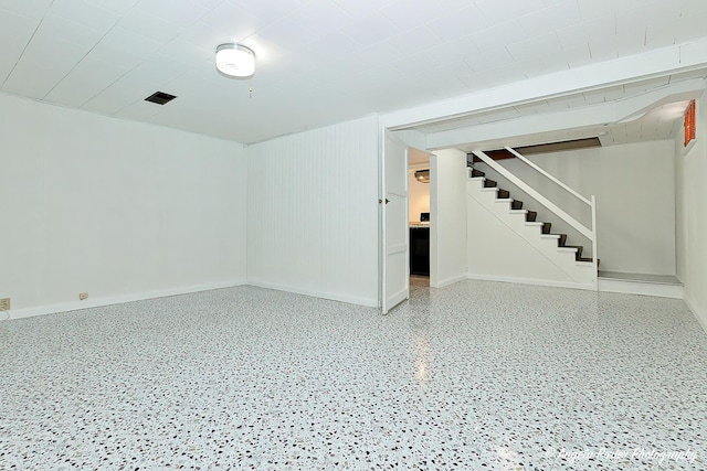interior space with baseboards, stairs, and speckled floor